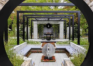 Black circular moon gate frames formal garden with central fire sculpture and symmetrical water features in Nagasaki Japan