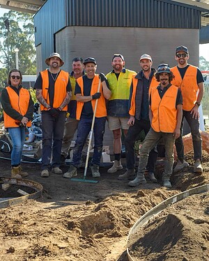Construction crew in high-vis safety vests posing together during landscape construction work at The Block Daylesford