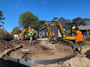 Construction crew with mini excavator and curved pool installation at The Block Daylesford House 5 project site