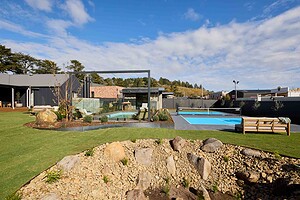 Modern backyard landscape featuring full-size Pickleball court, swimming pool, and mature Bottle Tree at Daylesford house