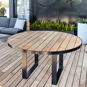 Round blackbutt timber dining table with steel frame on wooden deck terrace overlooking St Kilda rooftop garden