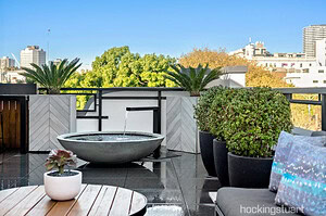 Concrete water bowl fountain on modern rooftop terrace with city skyline views in St Kilda