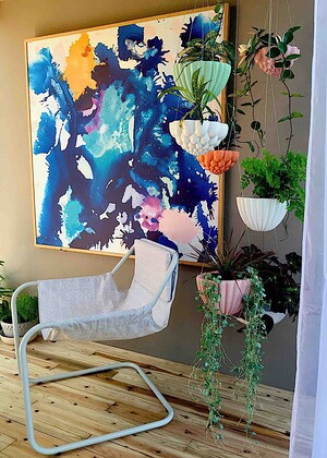 White sculptural hanging planters with trailing plants displayed in modern interior corner with abstract artwork, Nagasaki