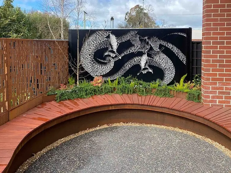 Hendricks House community courtyard in Buninyong by Paal Grant Designs – a moon gate, curved seating and stone paving designed to support gatherings and connection.